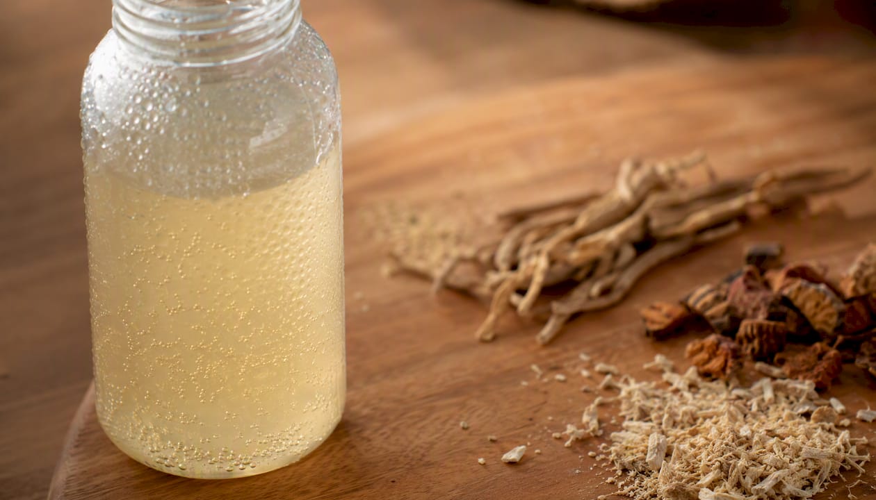 Close-up of probiotic drink bottle with herbal elements