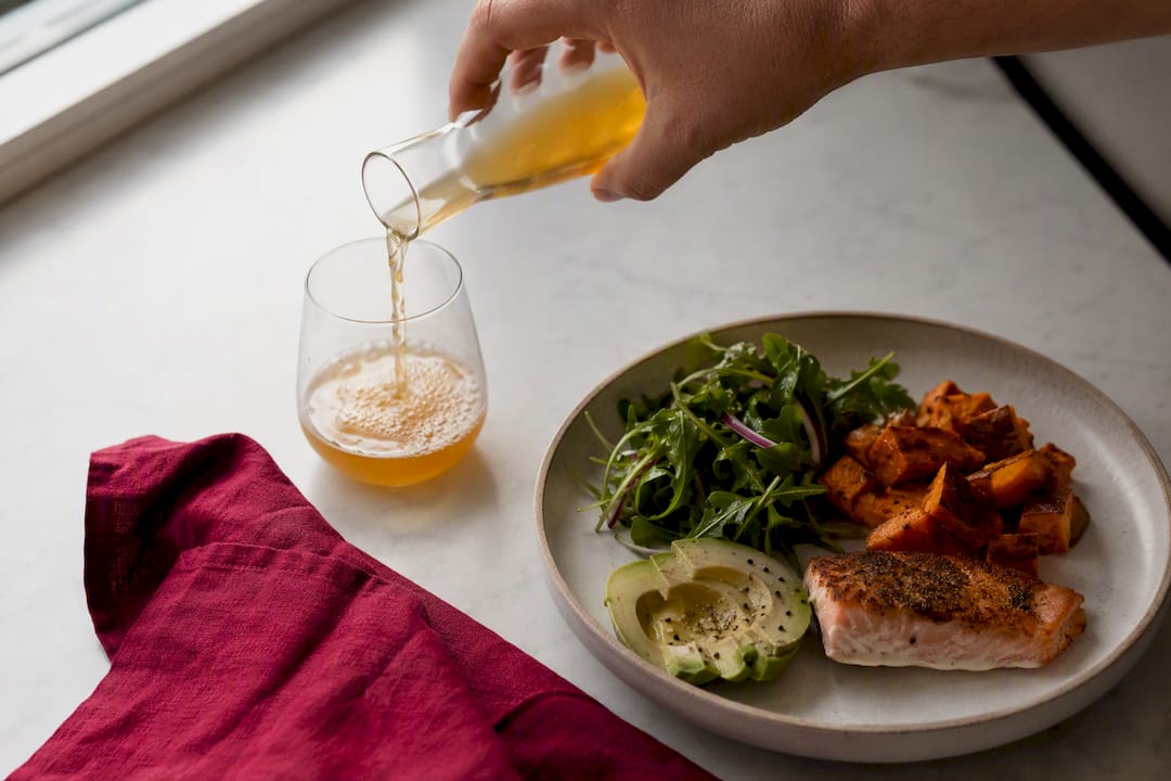 Small kombucha serving beside a meal